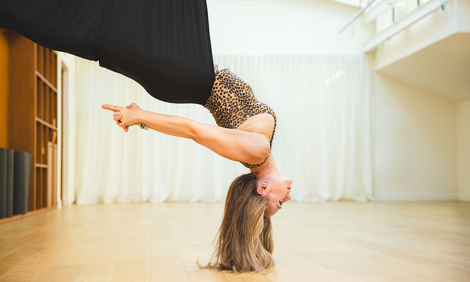 Posture d’équilibre en yoga aérien avec Sandra Larue